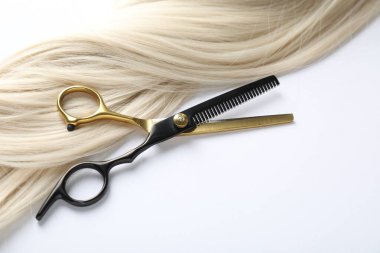 Beyaz arka planda saç tokası ve makas, üst tarafta. Metin için boşluk