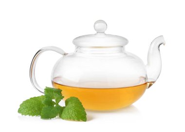 Aromatik limon merhemi çayı, cam çaydanlık ve beyaz yapraklar üzerinde izole edilmiş.