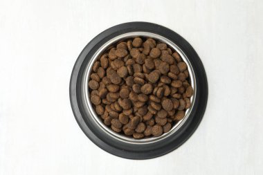 Beslenme kabındaki kuru hayvan mamaları arka planda, üst tarafta.