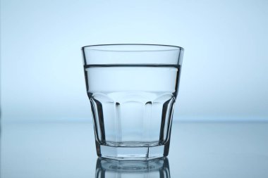 Ayna masasında taze su açık mavi gradyan arka planda, yakın plan