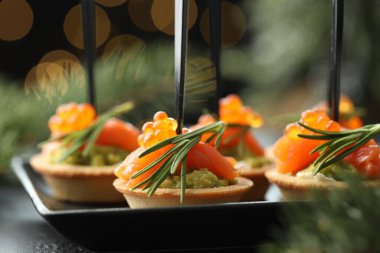 Lezzetli kanepeler ve Noel dekorasyonu masada, yakın plan. Bokeh etkisi