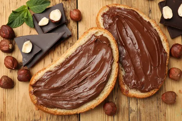 Lezzetli fındıklı tostlar, çikolata parçaları ve fındıklar ahşap masada, düz yatıyordu.