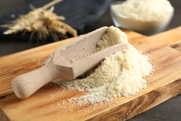 Koyu ahşap masaya un yığını ve kepçe, yakın plan.