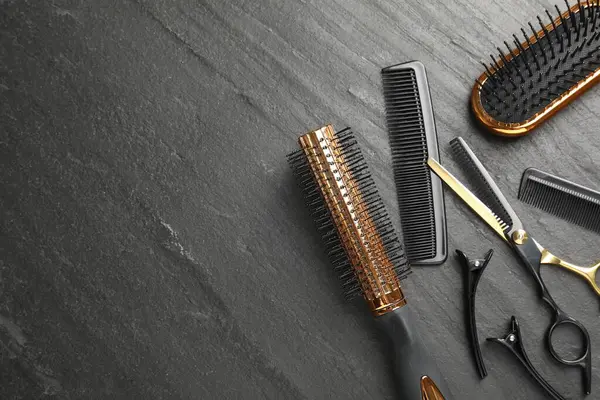 Farklı kuaförlerin aletleri karanlık masada, düz yerde. Metin için boşluk