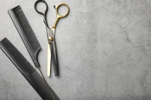 Gri masadaki farklı kuaför aletleri, düz yatış. Metin için boşluk