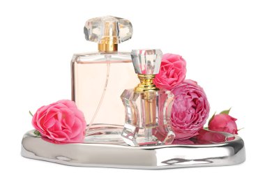 Farklı parfüm şişeleri ve beyaz güller.