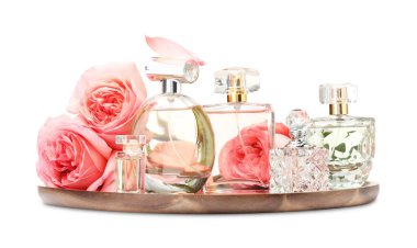 Birçok farklı parfüm şişeleri ve güller beyaz üzerine izole edilmiş.