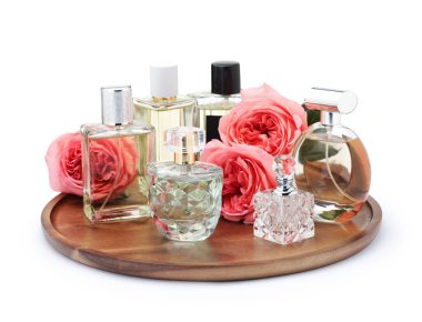 Birçok farklı parfüm şişeleri ve güller beyaz üzerine izole edilmiş.