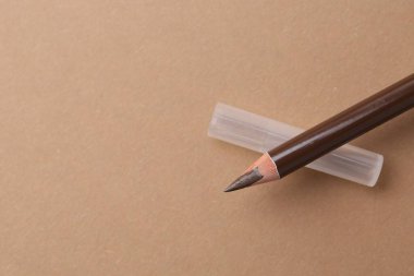 Kahverengi kaş kalemi, bej arka plan, üst manzara. Metin için boşluk