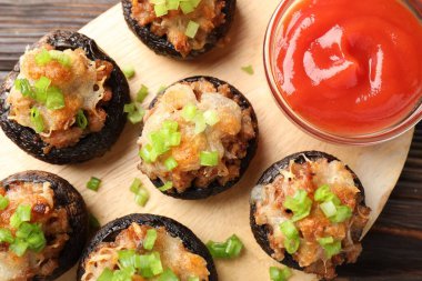 Lezzetli mantarlar ve ahşap masa üzerindeki sos, üst manzara.