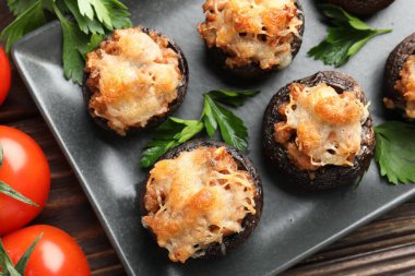 Maydanozlu mantarlar ve ahşap masada domatesler.