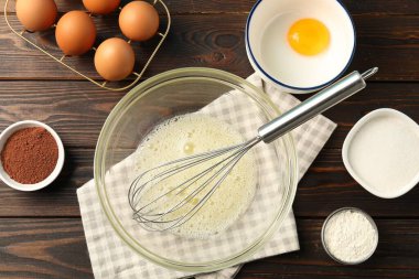 Krem şanti yapıyorum. Kase, çırpı ve malzemeler ahşap masada, düz yatıyordu.