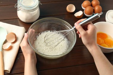 Ahşap masada yumurta beyazı çırpan kadın, yakın plan.