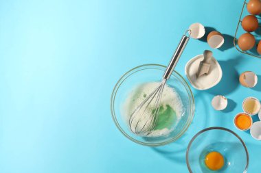 Kasede yumurta beyazı, çırpma, şeker ve yumurta açık mavi masada, düz. Metin için boşluk