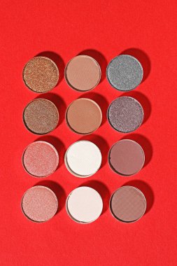 Kırmızı arka planda güzel göz farı dolgu kapları, düz yatış