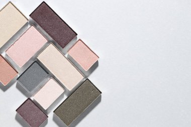 Işıklı arka planda güzel göz farı dolgu kapları, düz yatış. Metin için boşluk