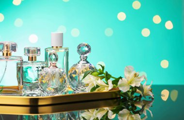 Ayna yüzeyinde birçok farklı parfüm şişesi ve çiçek bulanık ışıklı turkuaz arka planda, yakın plan