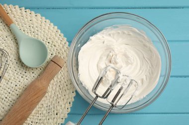 çırpılmış çırpılmış krema, yuvarlanan iğne ve kaşık açık mavi ahşap masa, düz yatıyordu.