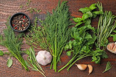 Farklı taze otlar ve baharatlar ahşap masada, düz yatıyordu.