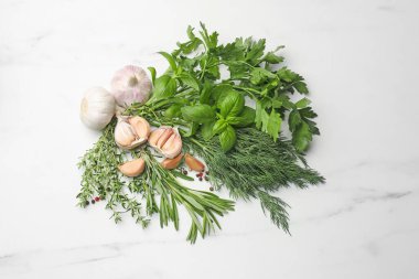 Farklı taze otlar ve baharatlar beyaz mermer masada, düz yatıyordu.