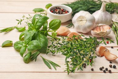 Beyaz ahşap masada farklı taze otlar ve baharatlar, yakın plan.