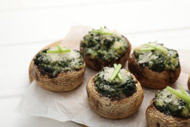 Beyaz ahşap masada servis edilen lezzetli mantarlar, yakın plan.