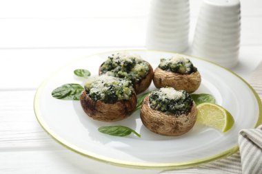 Beyaz ahşap masada servis edilen lezzetli mantarlar, yakın plan.