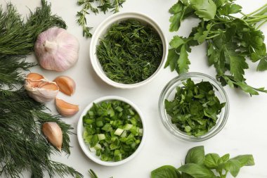 Beyaz masada farklı otlar ve baharatlar var.