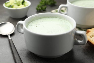 Gri masada servis edilen lezzetli salatalık çorbası, yakın plan.