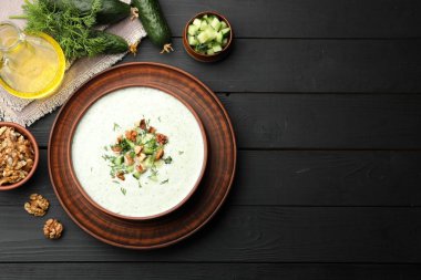 Lezzetli salatalık çorbası, dereotu, ceviz ve malzemeler siyah ahşap masa, düz yatak. Metin için boşluk