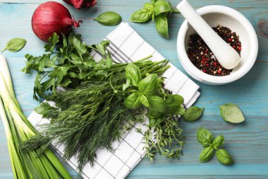 Farklı otlar ve baharatlar mavi ahşap masada, düz yerde.