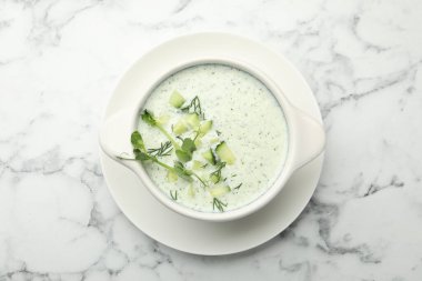 Beyaz mermer masa üzerinde dereotlu salatalık çorbası ve mikro yeşillikler.