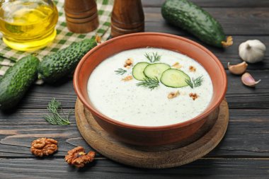 Dereotlu salatalık çorbası, ceviz ve ahşap masa malzemeleri, yakın plan.