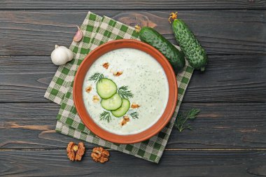 Dereotlu salatalık çorbası, ceviz ve malzemeler ahşap masada, düz yerde.