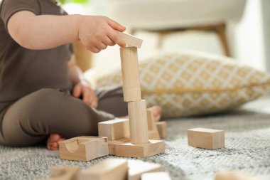 Evdeki ahşap yapı taşlarıyla oynayan sevimli küçük çocuk, yakın plan. Metin için boşluk