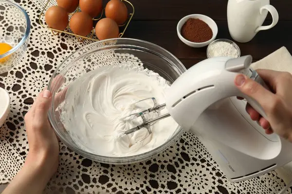 Masada el çırpıcı ile krem çırpan kadın, yakın plan.