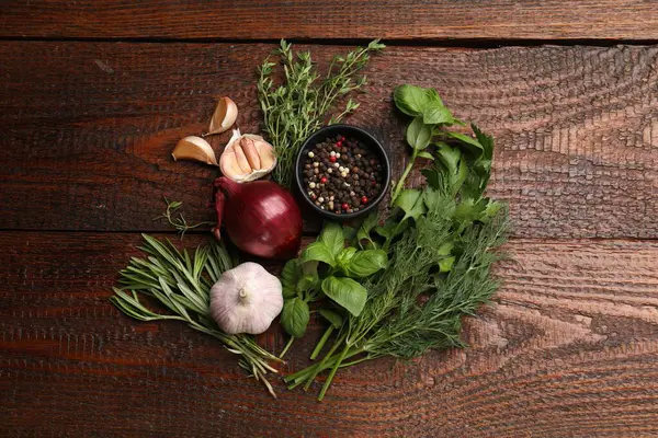 Farklı taze otlar ve baharatlar ahşap masada, düz yatıyordu.