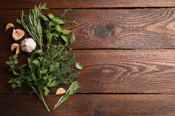 Farklı taze otlar ve baharatlar ahşap masada, düz yerde. Metin için boşluk