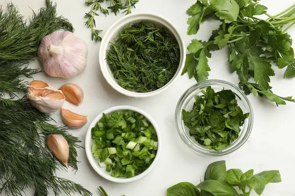 Beyaz masada farklı otlar ve baharatlar var.