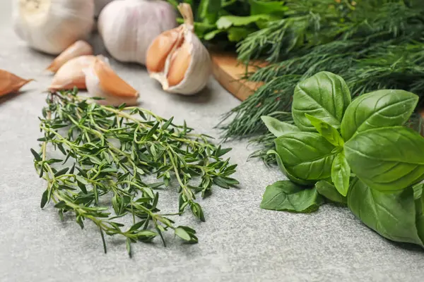 Gri masada farklı otlar ve baharatlar, yakın plan.