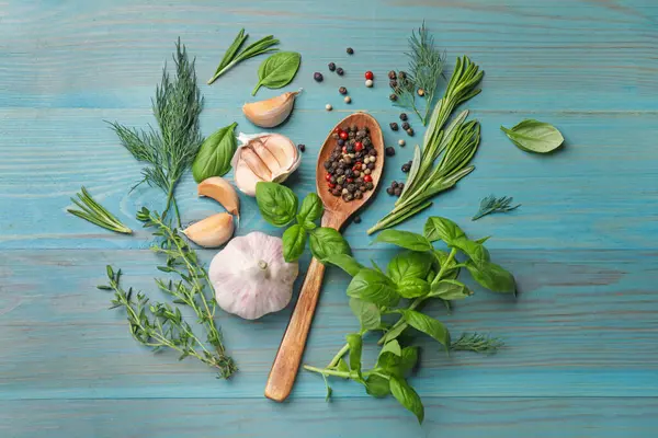 Farklı otlar ve baharatlar mavi ahşap masada, düz yerde.