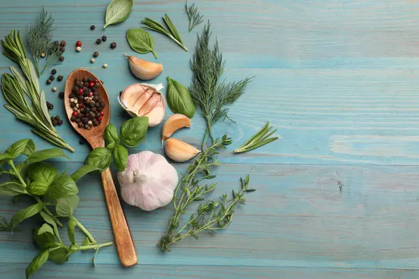 Farklı otlar ve baharatlar mavi ahşap masada, düz yerde. Metin için boşluk