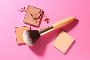 Kozmetik ürünlerinin kaplarını doldur ve pembe arka planda fırçala, düz yat