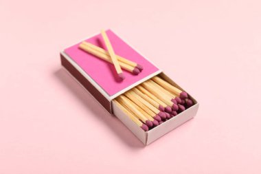 Pembe arkaplanda kibrit ve kutu, yakın plan