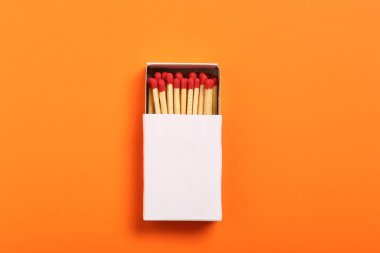 Turuncu arka plandaki kutuda kibrit, üst manzara. Tasarım için model