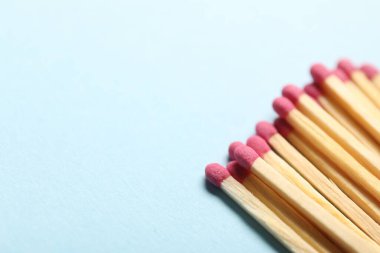 Açık mavi arka planda pembe başlıklı kibritler, yakın plan. Metin için boşluk