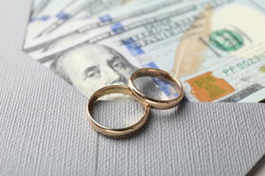 İki altın alyans, dolar banknotları ve zarf, yakın plan.