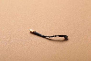 Bej arka planda yanmış bir kibrit, yakın plan.