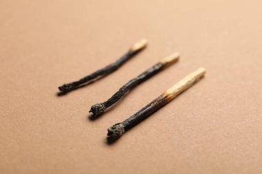 Bej arkaplanda yanmış kibritler, yakın plan görünümü