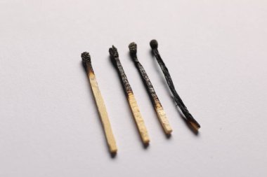 Gri arkaplanda yanmış kibritler, yakın plan görünümü